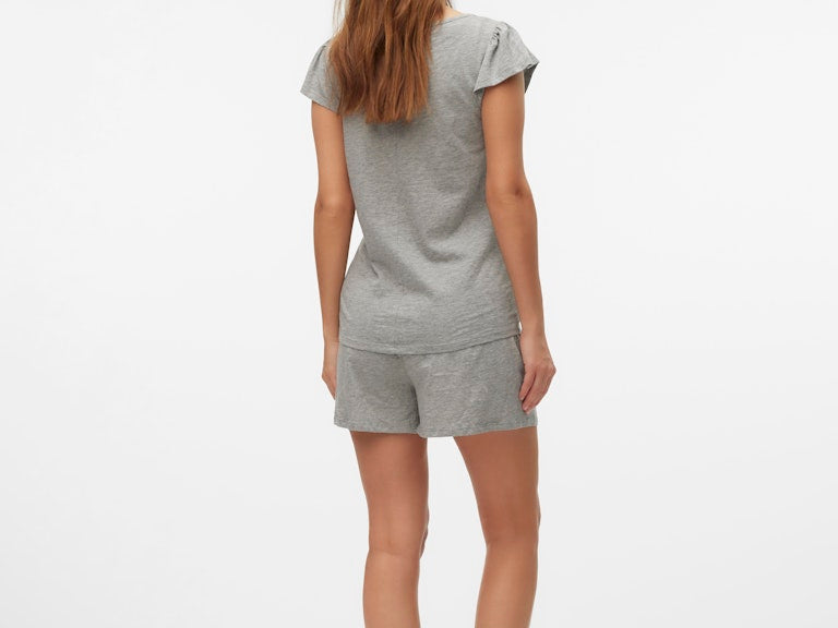 Woman wearing a gray pajama set on a white background