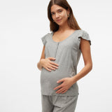Woman wearing a gray maternity outfit on a white background