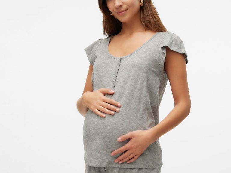 Woman wearing a gray maternity outfit on a white background