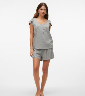 Woman wearing a gray pajama set on a white background