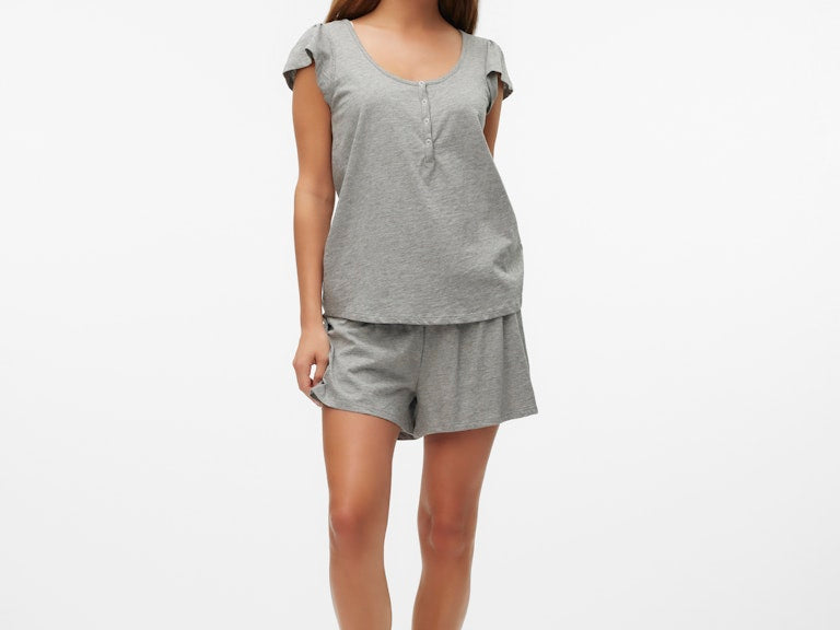 Woman wearing a gray pajama set on a white background