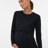 A pregnant woman wearing a black long-sleeve maternity top with a layered underbust design, shown against a plain light gray studio background.
