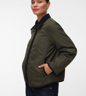Pregnant woman wearing Khaki green short jacket with black collar and zip front