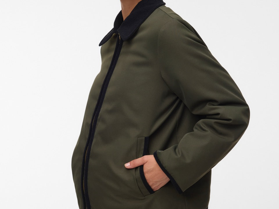 Pregnant woman wearing Khaki green short jacket with black collar and zip front