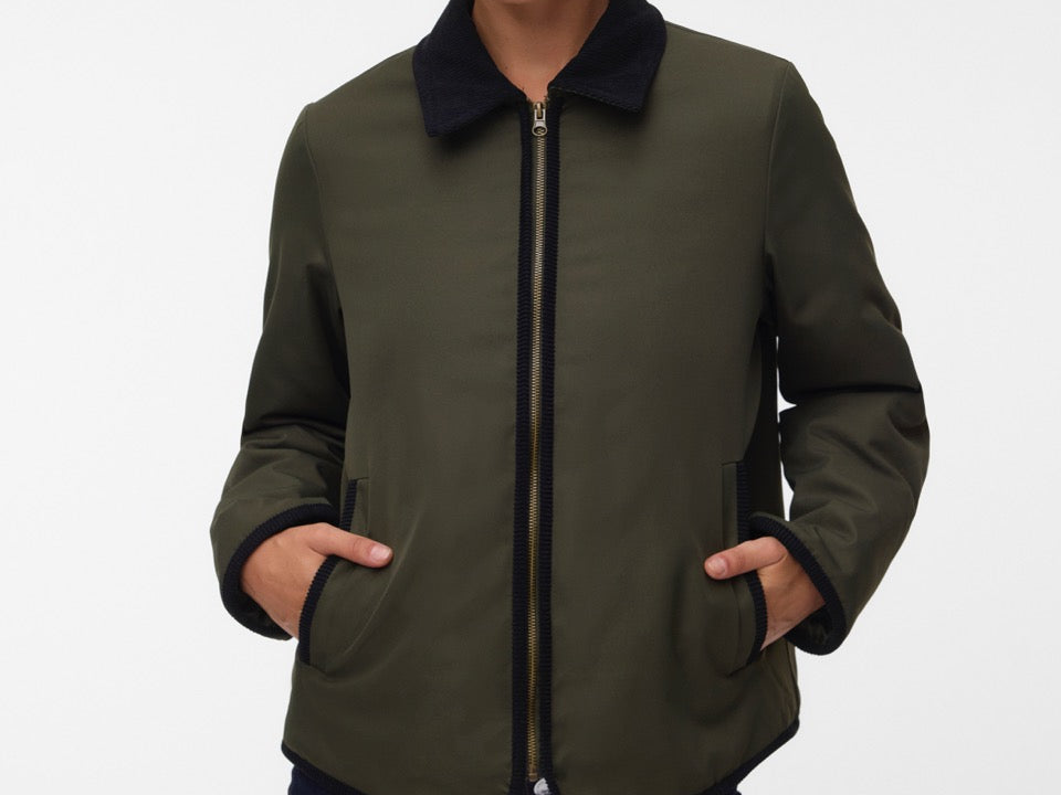 Pregnant woman wearing Khaki green short jacket with black collar and zip front