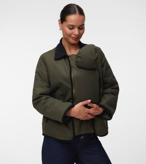 Woman with baby under coat, wearing Khaki green short jacket with black collar and zip front