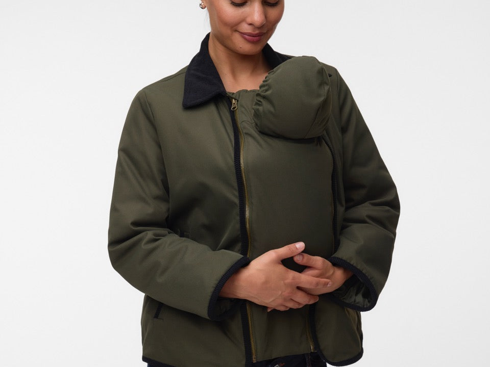 Woman with baby under coat, wearing Khaki green short jacket with black collar and zip front
