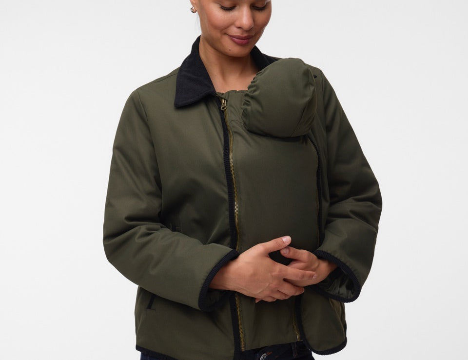 Woman with baby under coat, wearing Khaki green short jacket with black collar and zip front