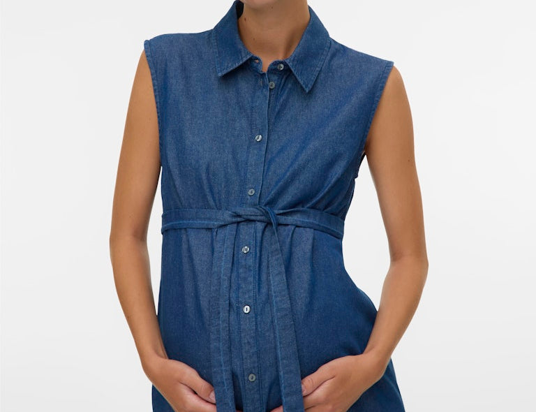 Woman wearing a blue sleeveless dress on a white background