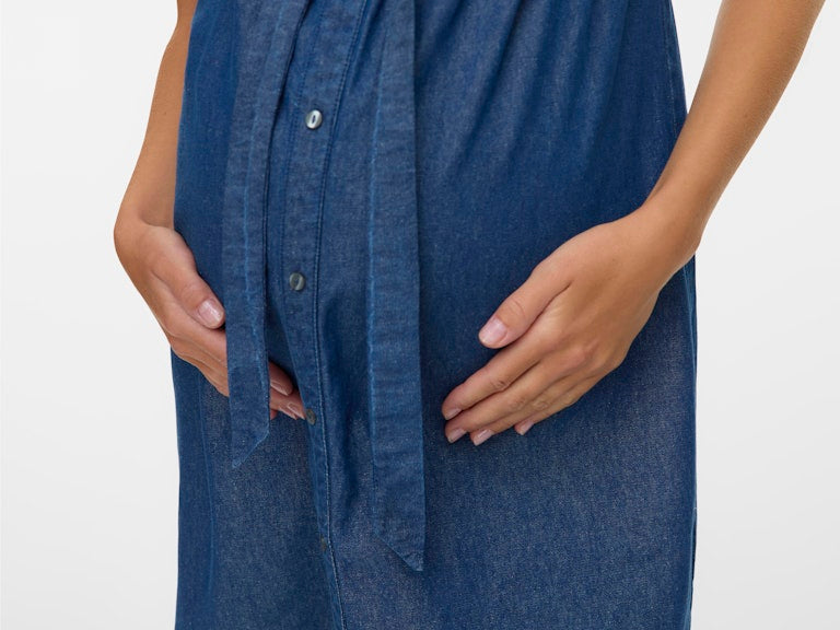 Blue denim dress worn by a person on a white background