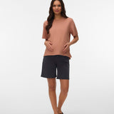 Woman wearing a brown top and black shorts on a white background