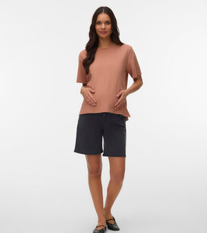 Woman wearing a brown top and black shorts on a white background