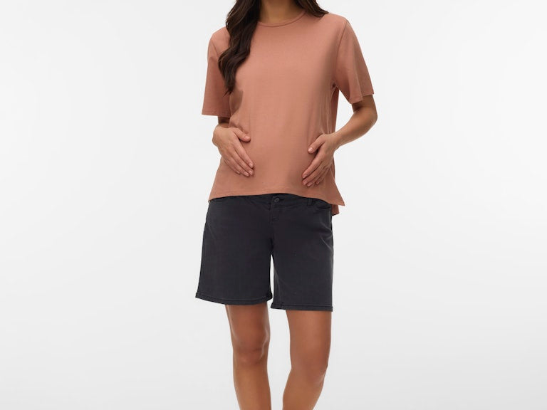 Woman wearing a brown top and black shorts on a white background