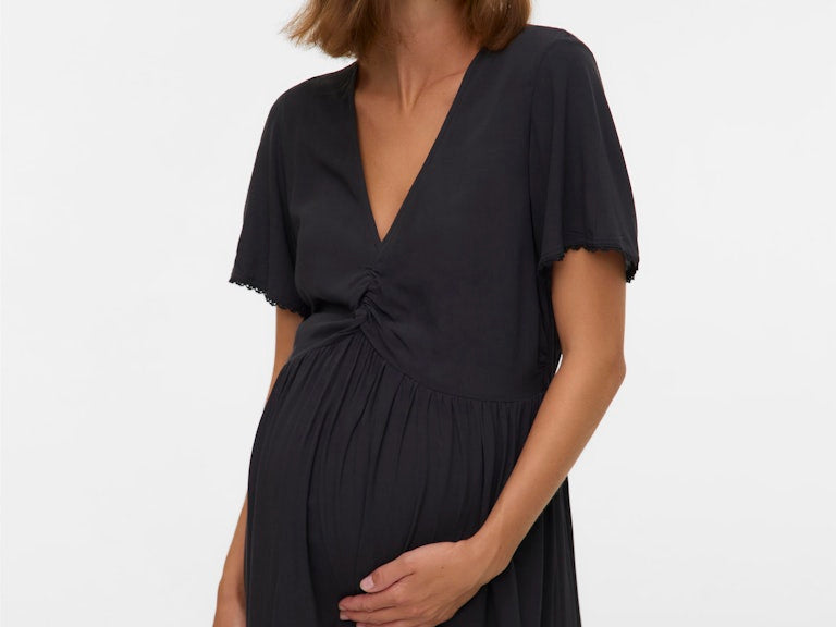 Woman wearing a black dress against a white background
