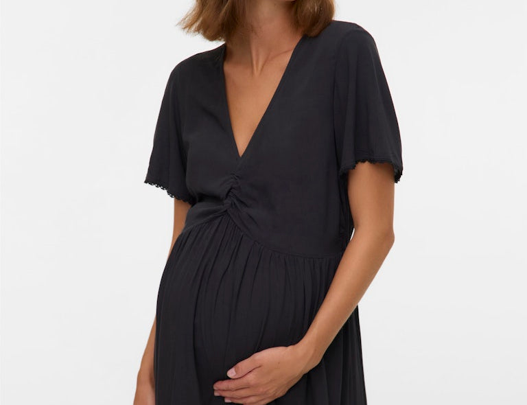 Woman wearing a black dress against a white background