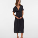 Woman wearing a black dress standing against a white background