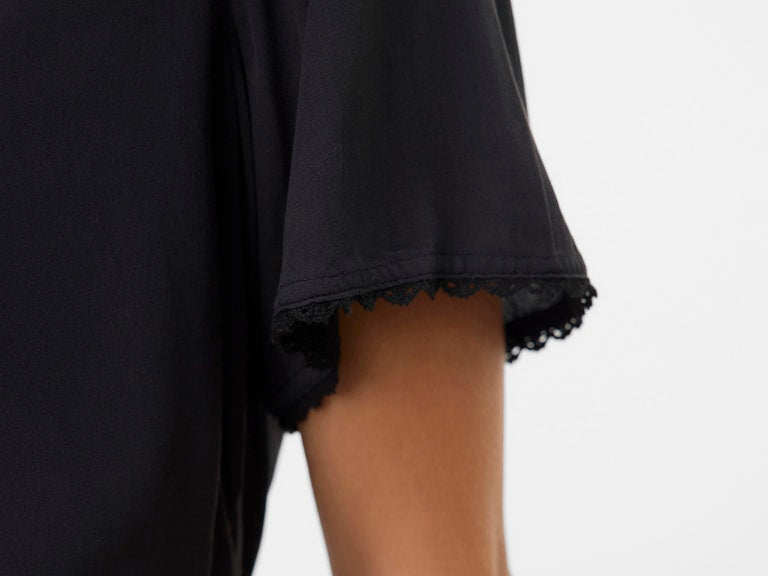 Black sleeveless top with lace trim on a white background