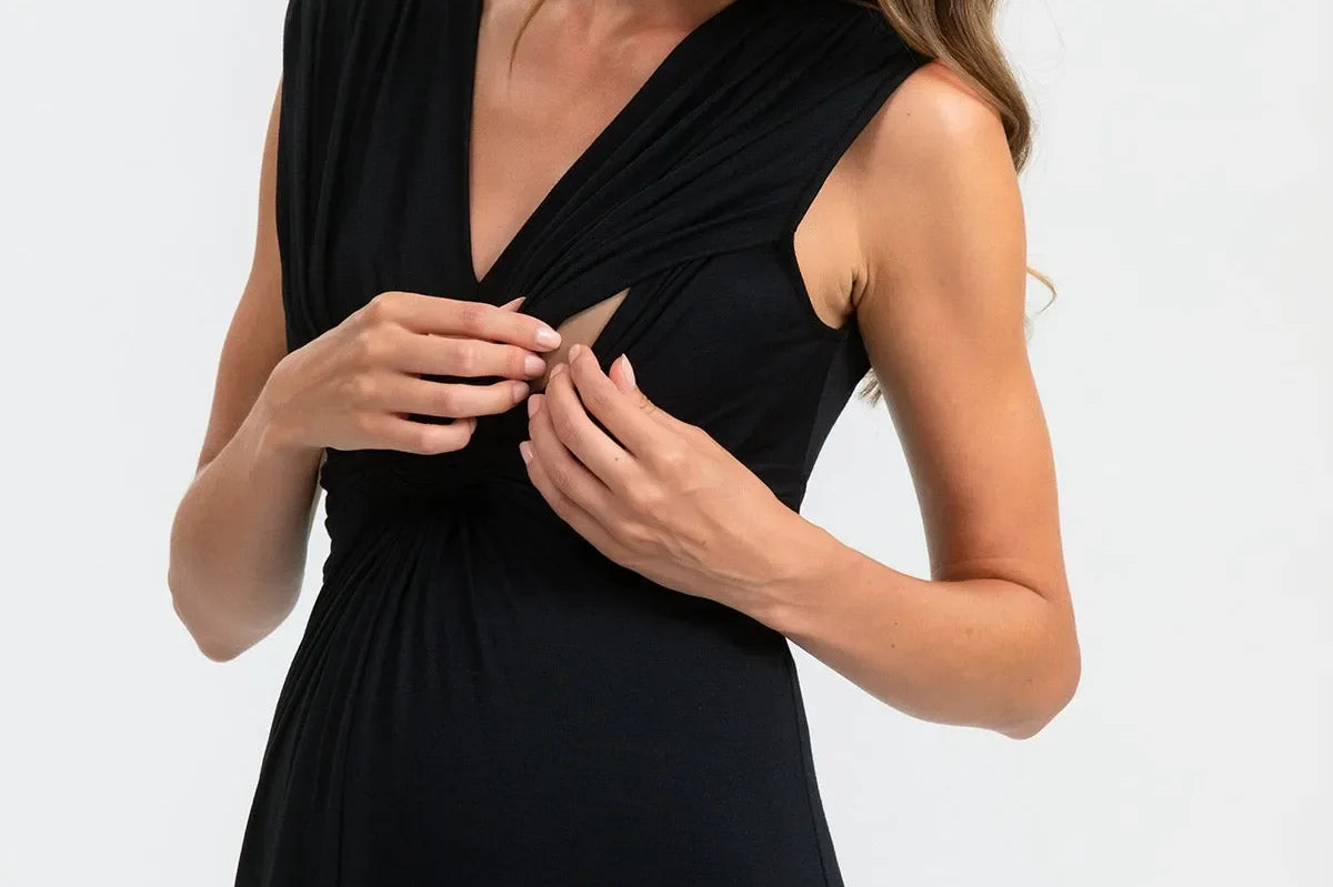 Woman wearing a black sleeveless dress against a white background