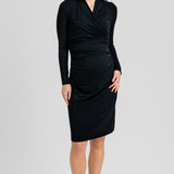 Black Helena nursing dress, front view on a standing woman, wrap-style neckline, long sleeves and ruched waist