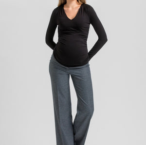 A pregnant woman modeling a black long-sleeve V-neck maternity top and heather gray wide-leg pants against a light gray studio background.