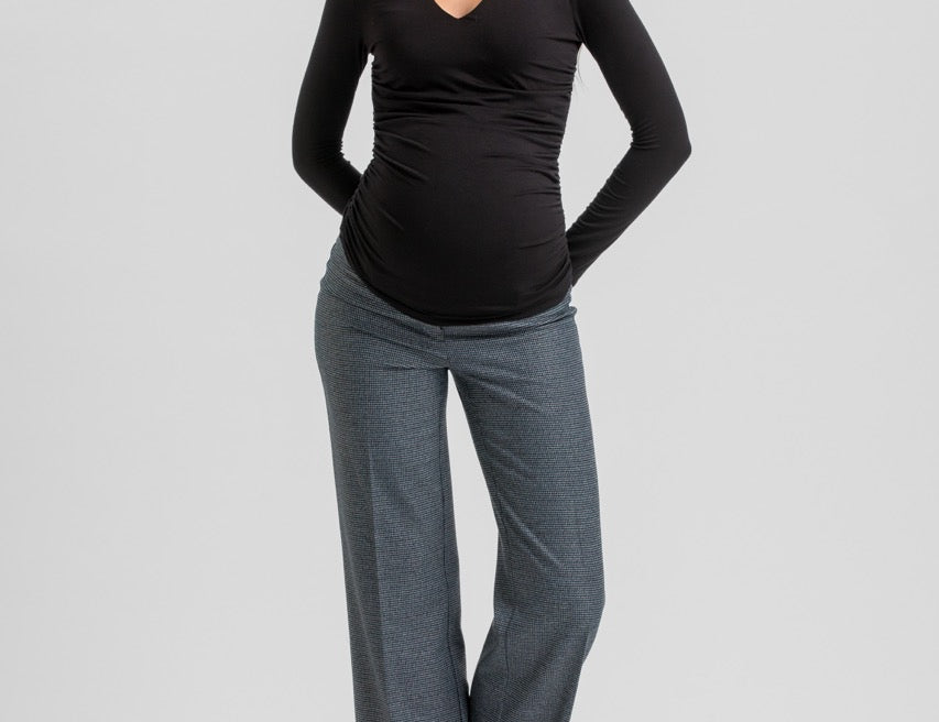 A pregnant woman modeling a black long-sleeve V-neck maternity top and heather gray wide-leg pants against a light gray studio background.