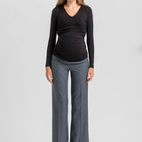 A woman modeling a black long-sleeve ruched V-neck top and heather gray wide-leg trousers against a light gray studio background.