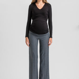 A woman modeling a black long-sleeve ruched V-neck top and heather gray wide-leg trousers against a light gray studio background.