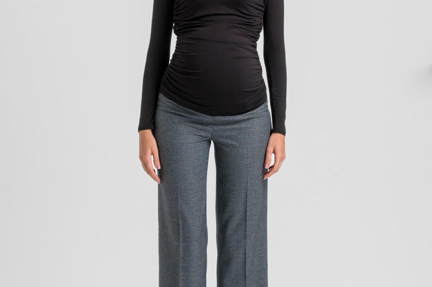 A woman modeling a black long-sleeve ruched V-neck top and heather gray wide-leg trousers against a light gray studio background.