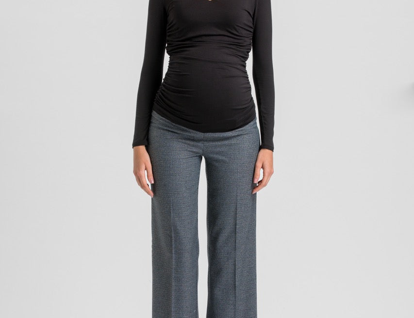 A woman modeling a black long-sleeve ruched V-neck top and heather gray wide-leg trousers against a light gray studio background.