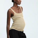 Woman wearing black linen trousers and beige vest top
