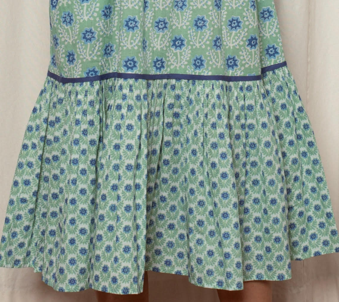 Green dress with blue floral pattern on a beige background