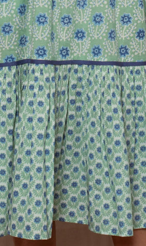 Green dress with blue floral pattern on a beige background