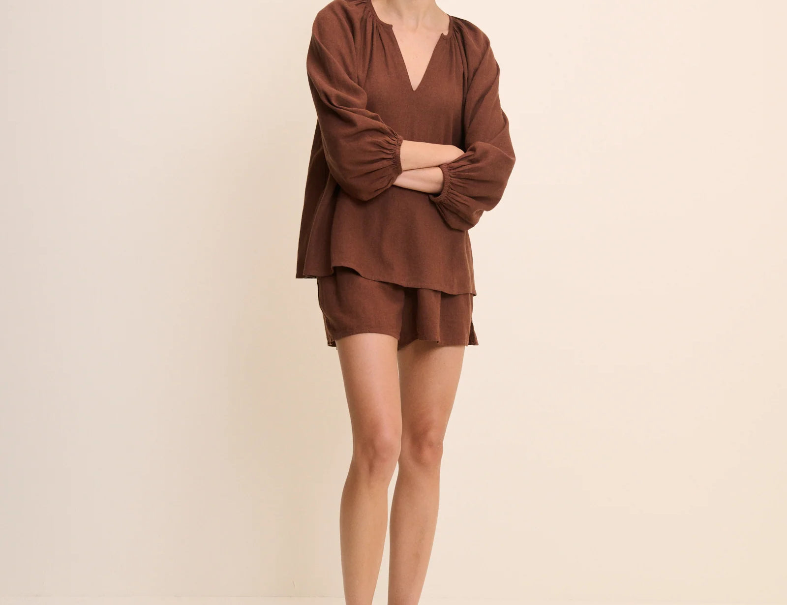 Woman wearing a brown outfit on a beige background