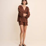 Woman wearing a brown outfit on a beige background