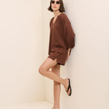 Woman wearing a brown outfit on a beige background