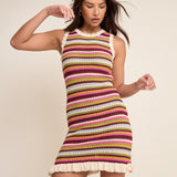 Woman wearing a colorful striped dress on a beige background