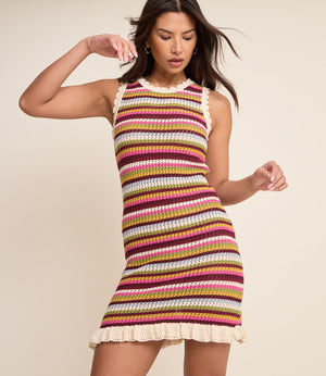 Woman wearing a colorful striped dress on a beige background