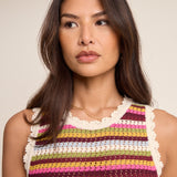 Woman wearing a colorful striped sleeveless top against a neutral background