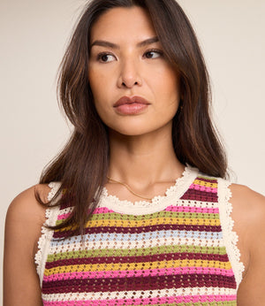 Woman wearing a colorful striped sleeveless top against a neutral background