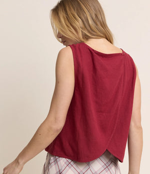 Woman wearing a red sleeveless top with a beige background