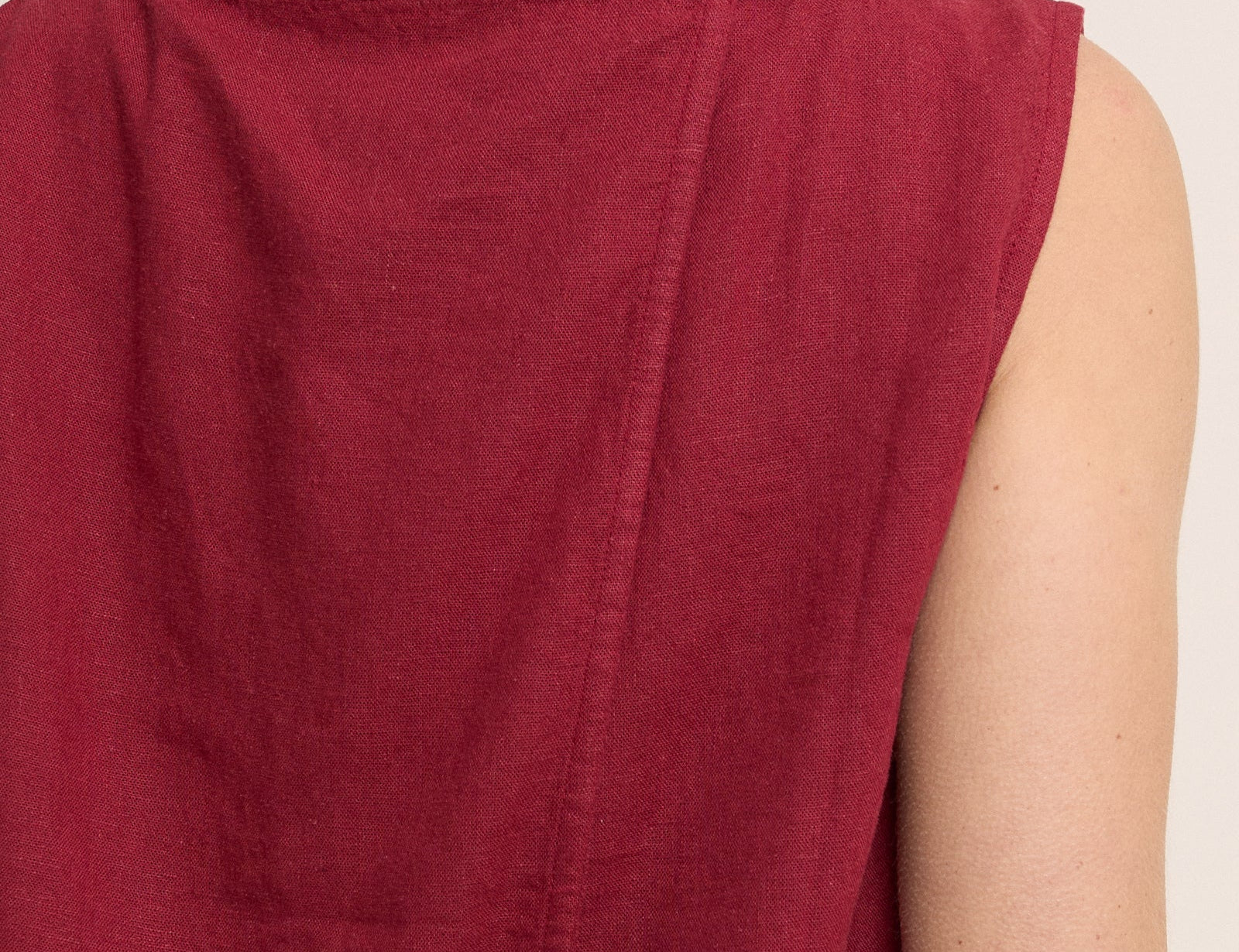 Red sleeveless top worn by a person on a plain background