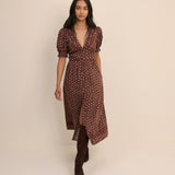 Woman wearing a brown patterned dress against a beige background