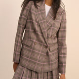 Plaid blazer and skirt set worn by a model on a beige background