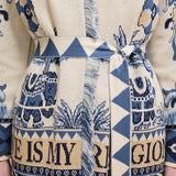Patterned fabric with blue and beige design featuring text and elephants.