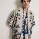 Woman wearing a patterned cardigan with a plain background