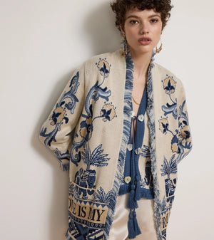 Woman wearing a patterned cardigan with a plain background