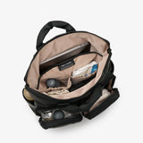 Open black backpack with items inside on a white background