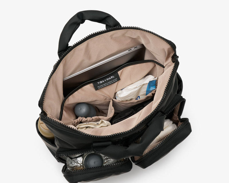 Open black backpack with items inside on a white background