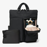 Black backpack with a smaller pouch, open to reveal baby items on a light gray background