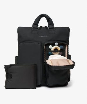 Black backpack with a smaller pouch, open to reveal baby items on a light gray background